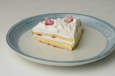 İki Japon çilekli pastası beyaz bir masada büyük bir tabakta..