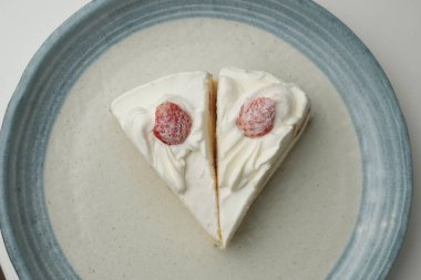 İki Japon çilekli pastası beyaz bir masada büyük bir tabakta..