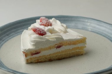 İki Japon çilekli pastası beyaz bir masada büyük bir tabakta..