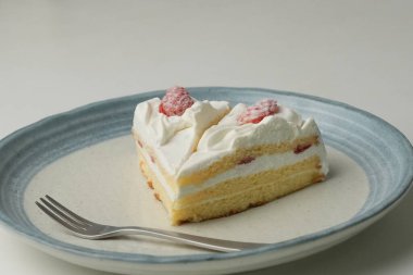 İki Japon çilekli pastası ve beyaz bir masada büyük bir çatal..