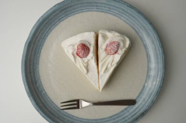 İki Japon çilekli pastası ve beyaz bir masada büyük bir çatal..