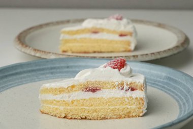 İki Japon çilekli pastası beyaz bir masada büyük bir tabakta..