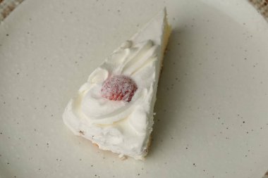 Beyaz bir masada büyük bir tabakta küçük bir Japon çilekli pasta..