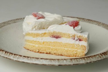 İki Japon çilekli pastası beyaz bir masada büyük bir tabakta..