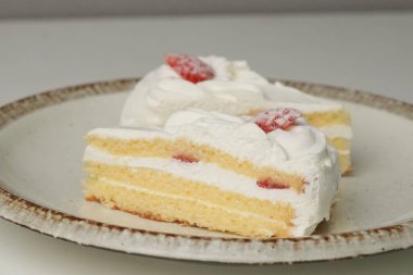 İki Japon çilekli pastası beyaz bir masada büyük bir tabakta..