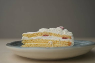 Japon çilekli pastası ve çatalı ahşap bir masadaki her büyük ve küçük tabakta..