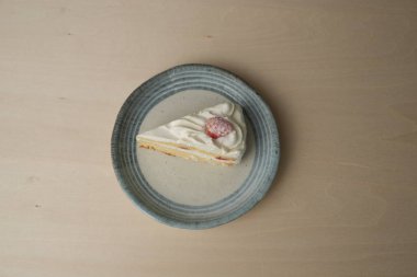 Japon çilekli pastası ve çatalı ahşap bir masadaki her büyük ve küçük tabakta..