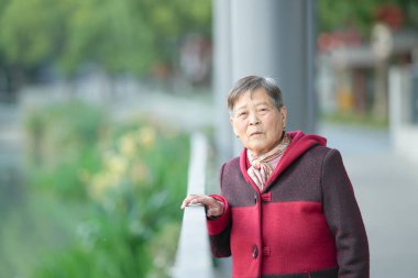 Soğuk bir kış akşamında, 70 'li yaşlarda Çinli bir kadın Çin' in Şangay bölgesindeki Qingpu Bölgesi 'nde bir nehir kıyısında durur..