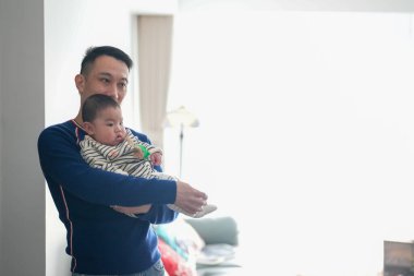 Noel kıyafetleri giyen altı aylık bir çocuk Çin 'de, Pudong Yeni Bölgesi, Şangay' da soğuk bir kış gününde Çinli bir aileden gelen babasıyla evde vakit geçiriyor..