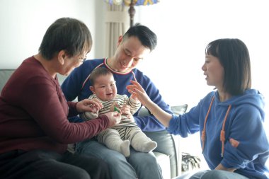 Noel kıyafetleri giyen 6 aylık bir çocuk soğuk bir kış günü Çin 'in Şangay şehrinde Pudong Yeni Bölgesi' nde Çinli bir ailenin babası, annesi ve büyükannesiyle birlikte evde vakit geçirir..