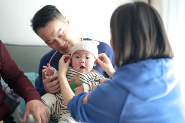 Noel kıyafetleri giyen 6 aylık bir çocuk soğuk bir kış günü Çin 'in Şangay şehrinde Pudong Yeni Bölgesi' nde Çinli bir ailenin babası, annesi ve büyükannesiyle birlikte evde vakit geçirir..