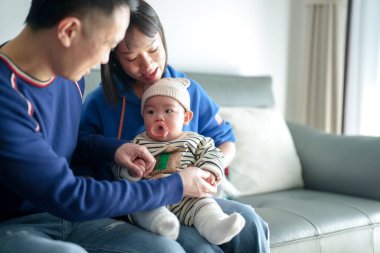 6 aylık bir çocuk Çin 'deki Pudong Yeni Alanı' ndaki bir apartman dairesinde soğuk bir kış günü Çinli bir aileden gelen anne ve babasıyla kanepede vakit geçiriyor.. 