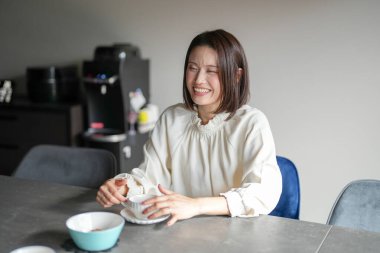 30 'lu yaşlarda Japon bir kadın öğleden sonra evde çay saatinin keyfini çıkarıyor..