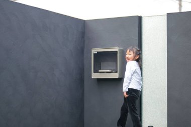 Japon bir ebeveyn ve çocuk, 20 'li yaşlarda bir adam ve 6 yaşında bir kız, evlerinin bahçesinde birbirlerine yeşil plastik toplar atarak oynuyorlar..