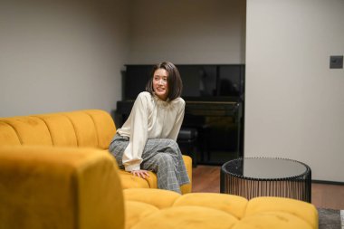 30 'lu yaşlarında bir Japon kadın oturma odasındaki kanepede dinleniyor..