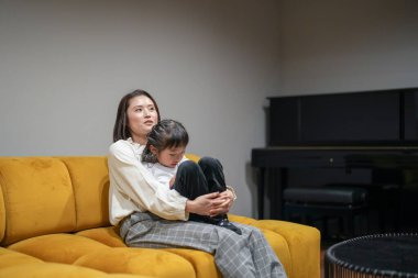 Japon bir ebeveyn ve çocuk, 30 'larında bir kadın ve 6 yaşında bir kız, oturma odasındaki bir kanepede dinleniyorlar..