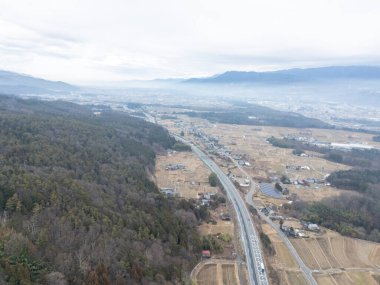 Iida şehrinin karla kaplı kış manzarasının insansız hava aracı kullanılarak çekilmiş görüntüsü.. 