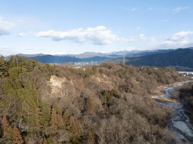 Pirinç tarlaları ve karla kaplı dağ da dahil olmak üzere özel evler de dahil olmak üzere kırsal alanın havadan çekilmiş fotoğrafı. Senjogatake ve Mt. Kiso-Komagatake, Komagane Şehri, Nagano Bölgesi, Japonya, kışın. 