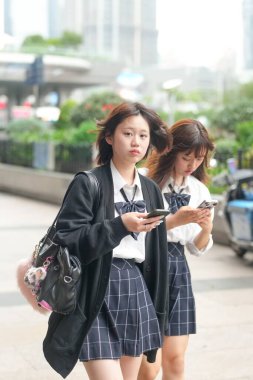 Haziran ayı başlarında Şangay 'da, Bund yakınlarında, üniformalı Japon liseli kızlar şehrin sokaklarında akıllı telefonlar kullanarak yürür, gençlik kültürünü şehrin tarihi yerleriyle harmanlarlar..