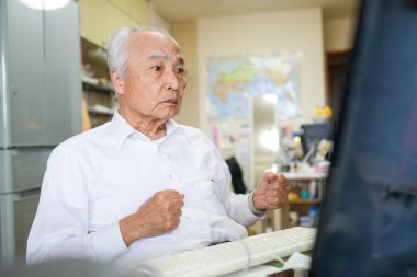 Japonya 'da sessiz bir dairede, 70' li yaşlarının sonunda beyaz tişörtlü bir adam masasında oturmuş bilgisayarında interneti karıştırıyor ve günlük barışçıl hayatını yansıtıyor.