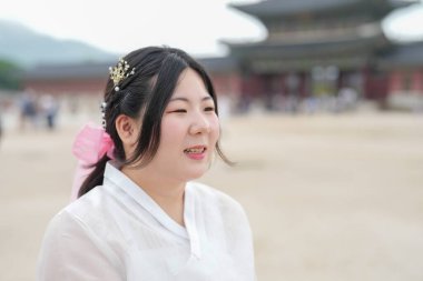Haziran 'da Seul' de, Gyeongbokgung Sarayı 'nda 30' lu yaşlardaki iki Koreli kadın, açık bir yaz gökyüzü altında, şirin pembe ve mavi Hanbok giyen kalabalığın arasında sohbet ediyorlar..