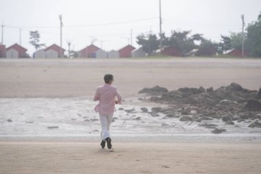 Haziran 2025 'te, 50' li yaşların sonlarında bir Koreli erkek ve kadın, sakin okyanus esintisinin, sessiz anların ve Incheon Metropolitan City 'de birbirlerinin arkadaşlığının tadını çıkararak, huzurlu deniz kıyısında yürürler..