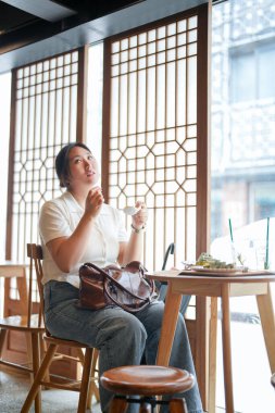 Pencere kenarındaki şık bir kafede, yirmili yaşlardaki sıradan elbiseli iki Koreli kadın içki ve şekerlerle oturur, yumuşak bahar ışığı altında gülüp sohbet ederler. Seul, Jongno Bölgesi, bahar..