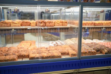 Bir alışveriş merkezinin içinde, merdivenler yüksek tavanların altında mırıldanırken, müşteriler dükkan vitrinlerinin önünden geçerken, modern bir sahne yansımaları oluşuyor. Hongkou Bölgesi, Şangay, Çin. 2 Haziran 2025. Bahar.