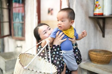Eski bir alışveriş merkezinde, Çinli bir aile mutfak setinde toplanıyor; bir yaşındaki bir çocuk bebek arabasında, on yaşın altındaki çocuklar ise otuzlu yaşlardaki yetişkinler yemek pişirip sohbet ederken. Şangay, Çin. Bahar.