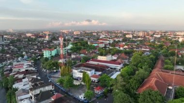 Gün batımında Yogyakarta şehrinde, Endonezya 'daki Merapi Dağı manzaralı havadan manzaralı evler..