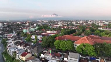 Gün batımında Yogyakarta şehrinde, Endonezya 'daki Merapi Dağı manzaralı havadan manzaralı evler..