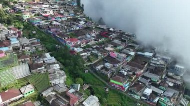 Sumbing Dağı, Magelang, Central Java, Endonezya 'daki Nepal Van Java' daki güzel renkli köylerin hava manzarası. Sumbing Dağı 'nın yamaçlarında, bulutların ve sislerin arkasında saklı bir köy..