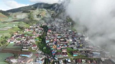 Sumbing Dağı, Magelang, Central Java, Endonezya 'daki Nepal Van Java' daki güzel renkli köylerin hava manzarası. Sumbing Dağı 'nın yamaçlarında, bulutların ve sislerin arkasında saklı bir köy..