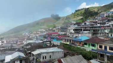 Sumbing Dağı, Magelang, Central Java, Endonezya 'daki Nepal Van Java' daki güzel renkli köylerin hava manzarası. Sumbing Dağı 'nın yamaçlarında, bulutların ve sislerin arkasında saklı bir köy..