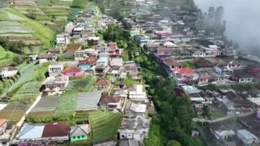 Sumbing Dağı, Magelang, Central Java, Endonezya 'daki Nepal Van Java' daki güzel renkli köylerin hava manzarası. Sumbing Dağı 'nın yamaçlarında, bulutların ve sislerin arkasında saklı bir köy..
