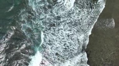 Koyu okyanus dalgalarının beyaz yıkamalı havadan görünüşü, gök mavisi suyla kaplanmış kahverengi resif beyaz deniz köpüğüne çarpan dalgalar..