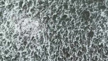 Koyu okyanus dalgalarının beyaz yıkamalı havadan görünüşü, gök mavisi suyla kaplanmış kahverengi resif beyaz deniz köpüğüne çarpan dalgalar..