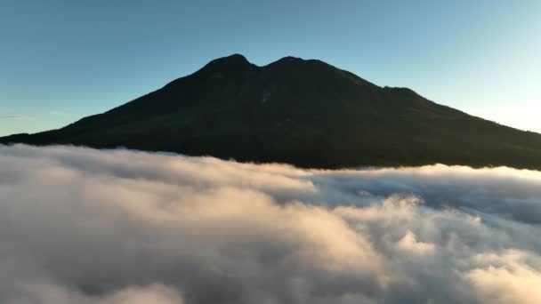 インドネシア 日の出の雲の上のマウントローウの空中ビュー — ストック動画