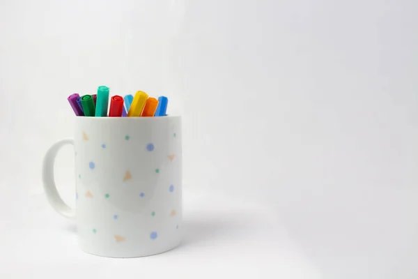 Start the new school year with a mug full of creative inspiration. This stock photo shows a mug on a white background, replete with ready-to-use colored markers. With every sip of your favorite beverage, you\'ll be able to immerse yourself in a world