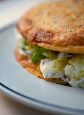 İspanyol omleti olarak da bilinen patatesli nefis sebzeli omlet, beyaz bir tabakta, temiz beyaz arka planda servis ediliyor. Bu klasik İspanyol yemeği taze sebze ve yumurtalarla yapılır. Lezzetli ve doyurucu bir yemek yaratır.