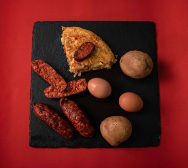 İspanyol mutfak mirasına bu ağız sulandıran patates omletini parlak, siyah bir tepside servis et. Her dilim taze patateslerin, taze çiftlik yumurtalarının ve baharatlı sucuğun enfes bir karışımını ortaya çıkarıyor.