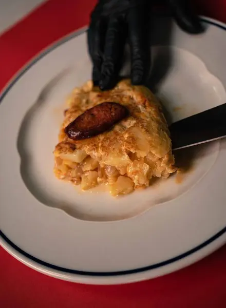 İspanyol patatesli omleti mutfaktan çıkarken nefis Chistorra dilimleriyle süslenmiş, sevgi dolu bir Bask sucuğu bekliyor. Cızırdayan korizonun aroması yumuşak patateslerle uyumlu bir şekilde harmanlanarak, bir 