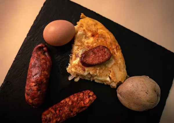 İspanyol mutfak mirasına bu ağız sulandıran patates omletini parlak, siyah bir tepside servis et. Her dilim taze patateslerin, taze çiftlik yumurtalarının ve baharatlı sucuğun enfes bir karışımını ortaya çıkarıyor.