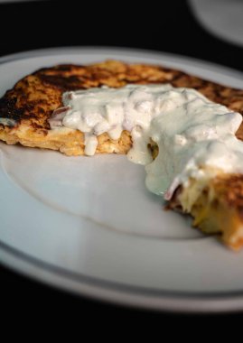 Lezzetli patates omletimizle İspanyol geleneğinin ve İtalyan yeteneğinin enfes bir karışımını deneyin. İçinde taze patates, yumurta ve lezzetli bir carbonara sosu var. El değmemiş beyaz bir tabakta, çarpıcı bir siyah zemine karşı servis edilmiş, mükemmel. 