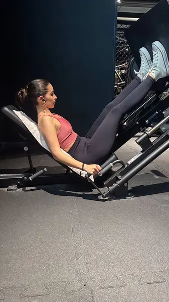 Spor salonunda bacaklarını çalıştırmaya odaklanan genç bir kadının ithafına tanık olun. Daha düşük bir vücut egzersizi seansında bacak kaslarını güçlendirmek ve geliştirmek için basın makinesinden yararlanıyor.