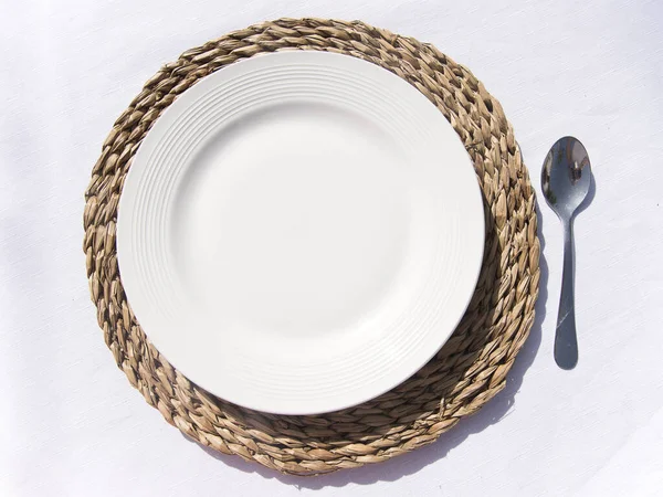 white plate on wood on white tablecloth