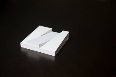 Siyah arka planda çatısı olan beyaz ölçekli bir bina..