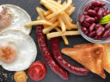 Fasulyeli, yumurtalı, sosisli, kızarmış patatesli ve tostlu kahvaltı. Genel giderler