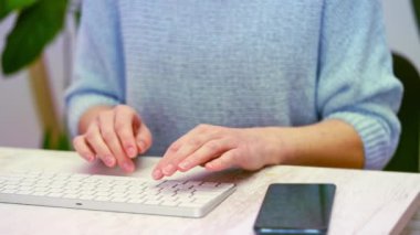 Beyaz klavyede yazan kadın. 