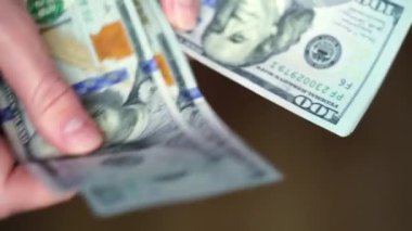 Kadın elleri 100 dolarlık banknotları sayıyor..